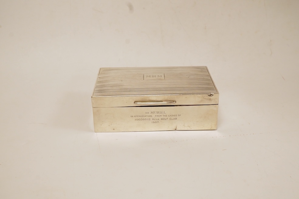 A George V silver mounted rectangular cigarette box, with later engraved inscription, Birmingham, 1932, 13.7cm, together with a similar silver vesta case and two modern silver wine labels. Condition - poor to fair